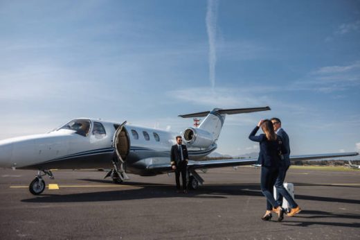 A group of professionals in business attire walking towards a corporate jet on a sunny tarmac, symbolizing business travel and success.